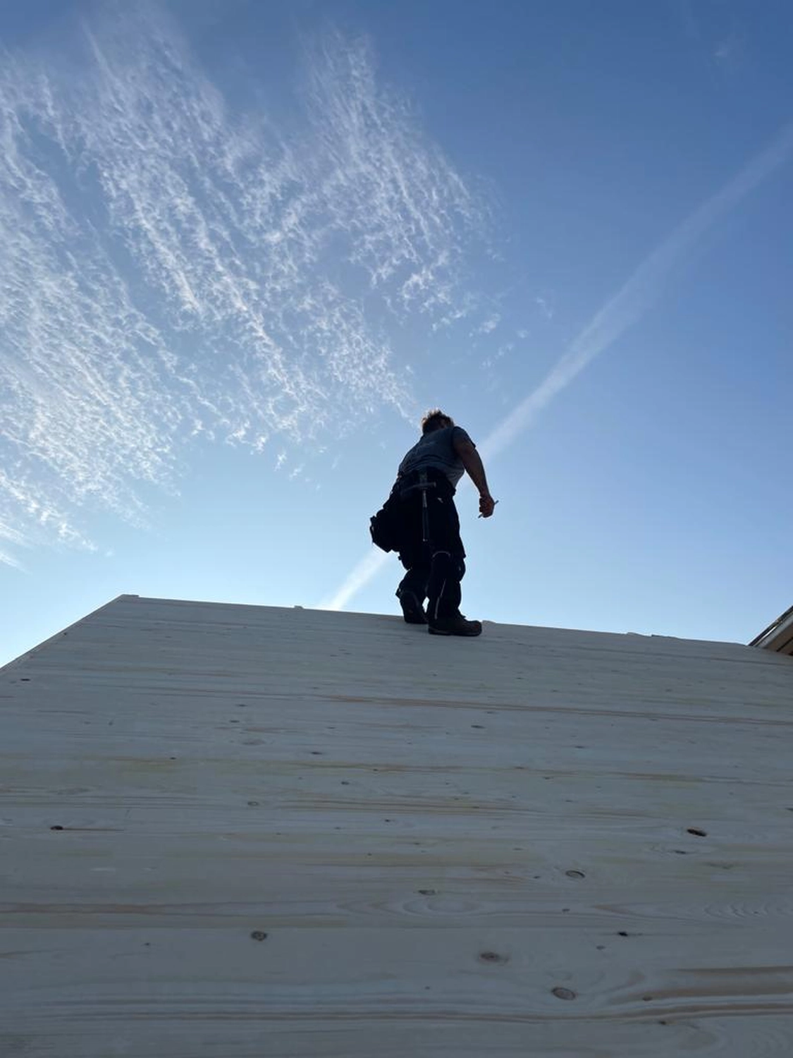 Eggelmann-Bau, ein Arbeiter steht auf einem Holzdach